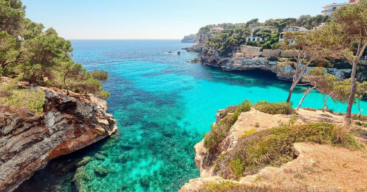 Stunning beach in Mallorca with turquoise water, white sand and lush foliage
